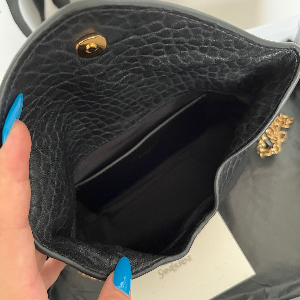 Black textured leather YSL bag interior with gold logo stud, open top