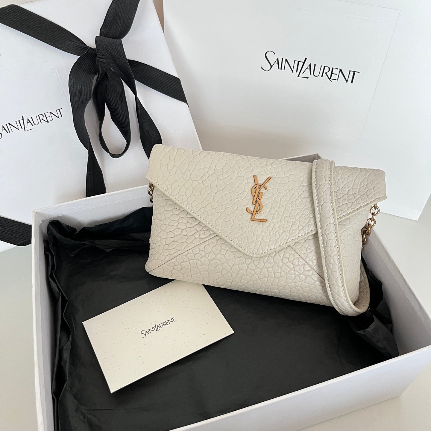 Light off-white textured shoulder bag with flap and gold-tone YSL logo hardware