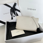 Light off-white textured shoulder bag with curved flap, chain strap, and gold-tone hardware