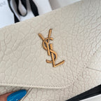 Close-up of light off-white textured flap with gold-tone YSL logo and stitched edge