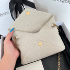 Light off-white textured shoulder bag with front flap, gold button accents, and chain strap
