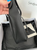YSL bag side view, black pebbled leather with stitched trim and top handle