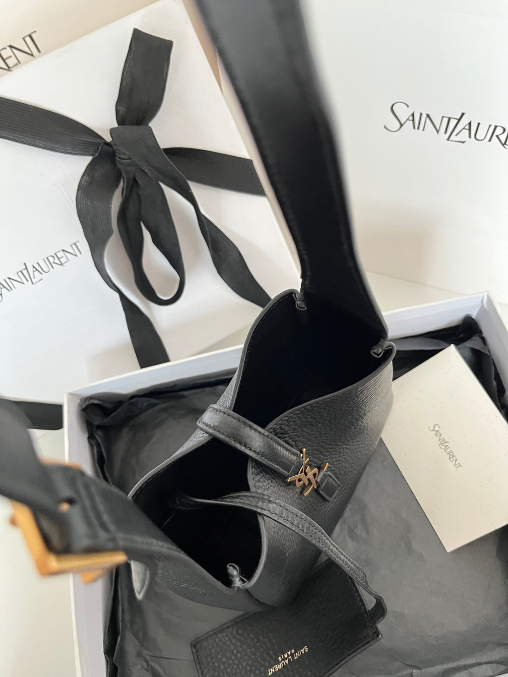 YSL bag in open view, black leather with gold monogram on front