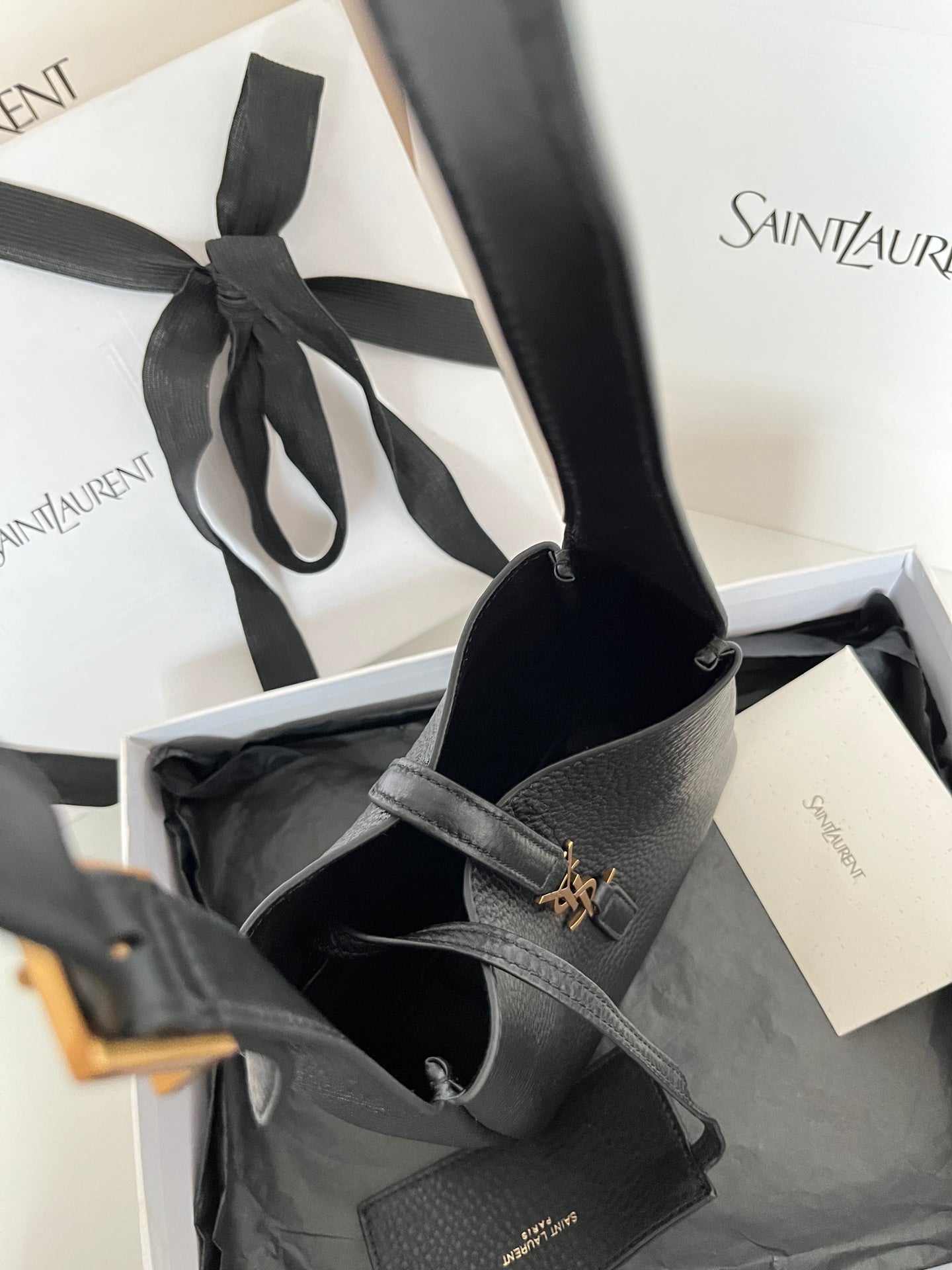 YSL bag in open view, black leather with gold monogram on front