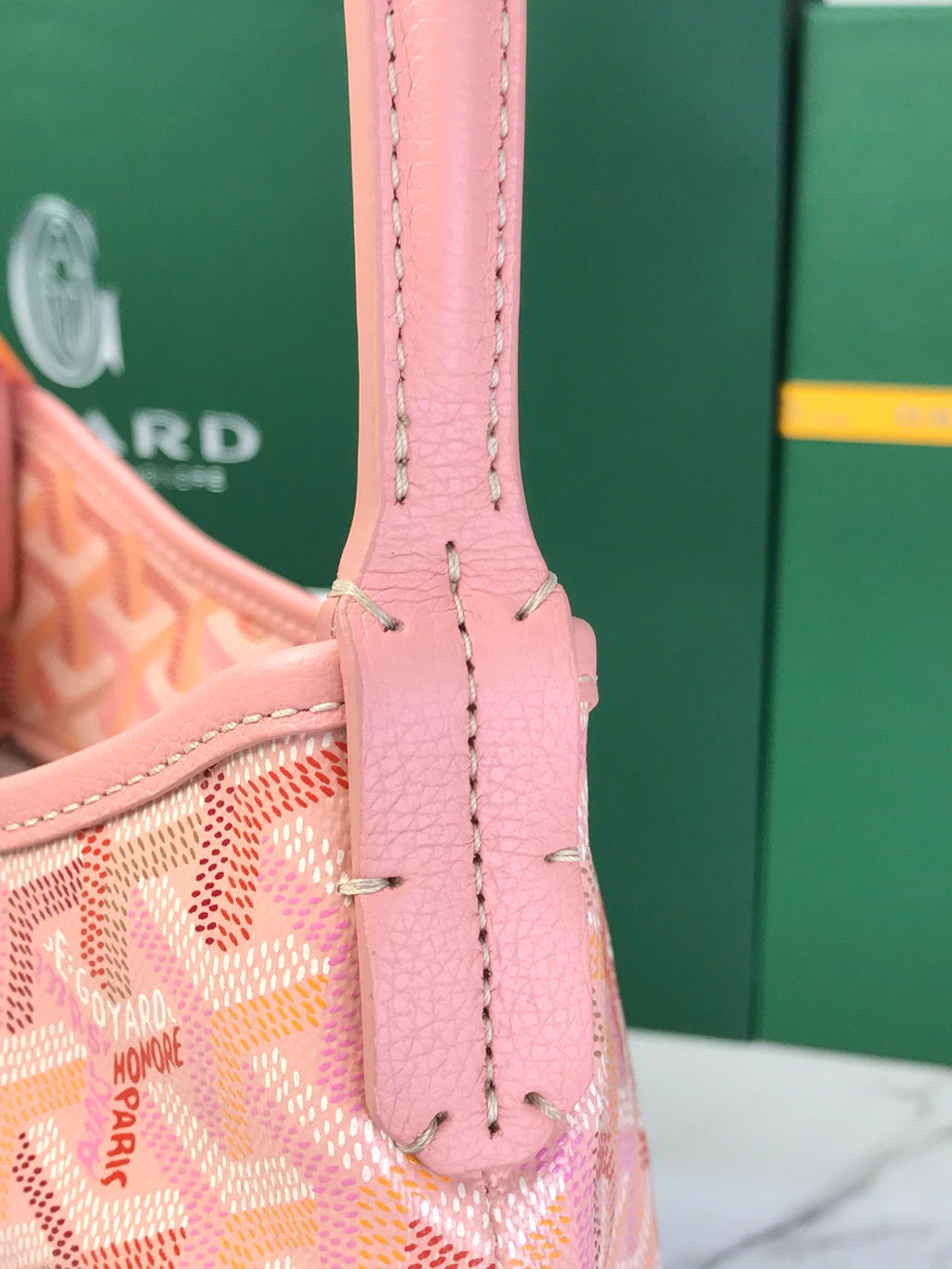 Pink leather-and-canvas bag handle with side hardware and stitched seams