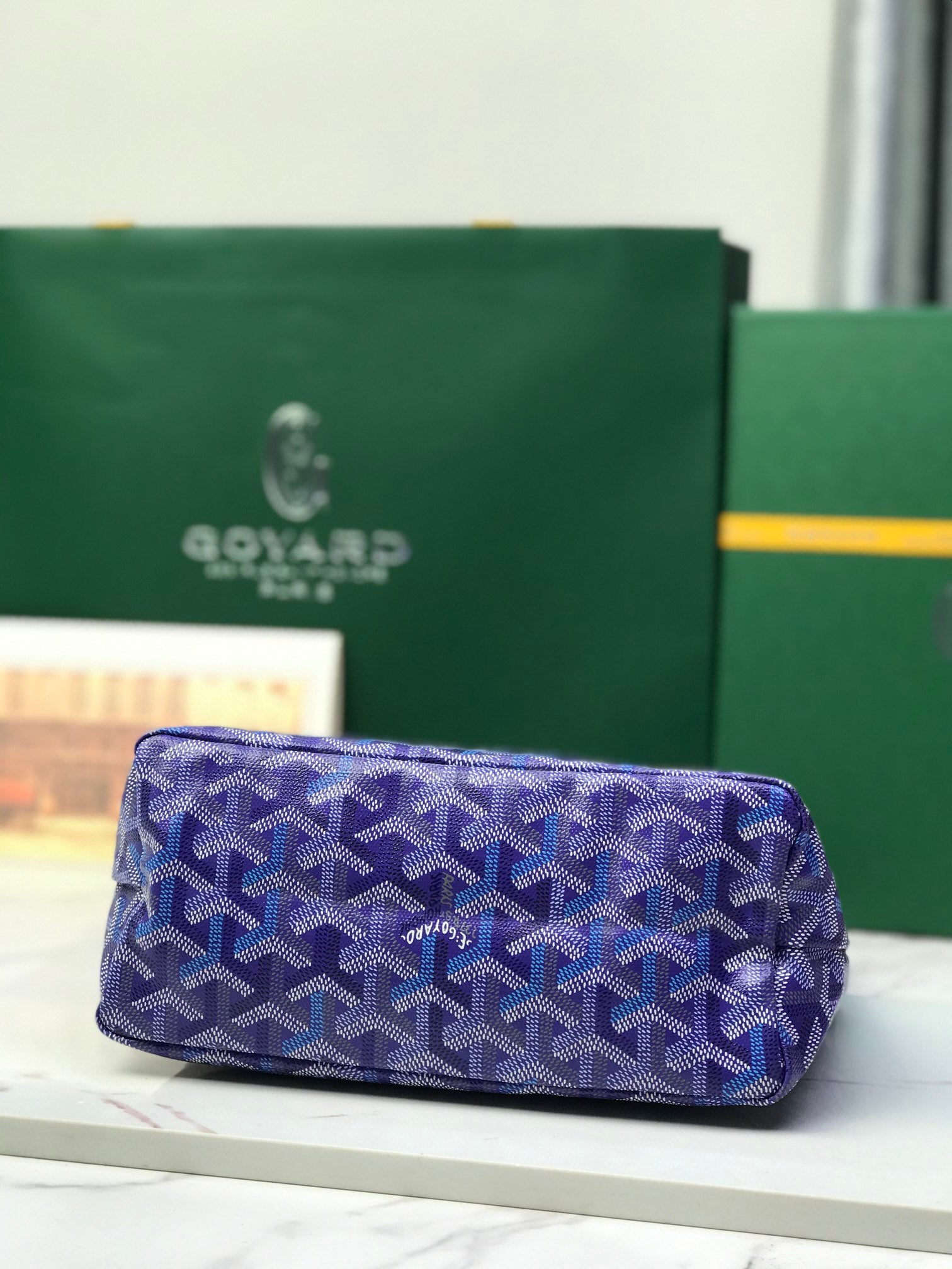 Purple patterned Goyard bag with zip top and front panel pocket