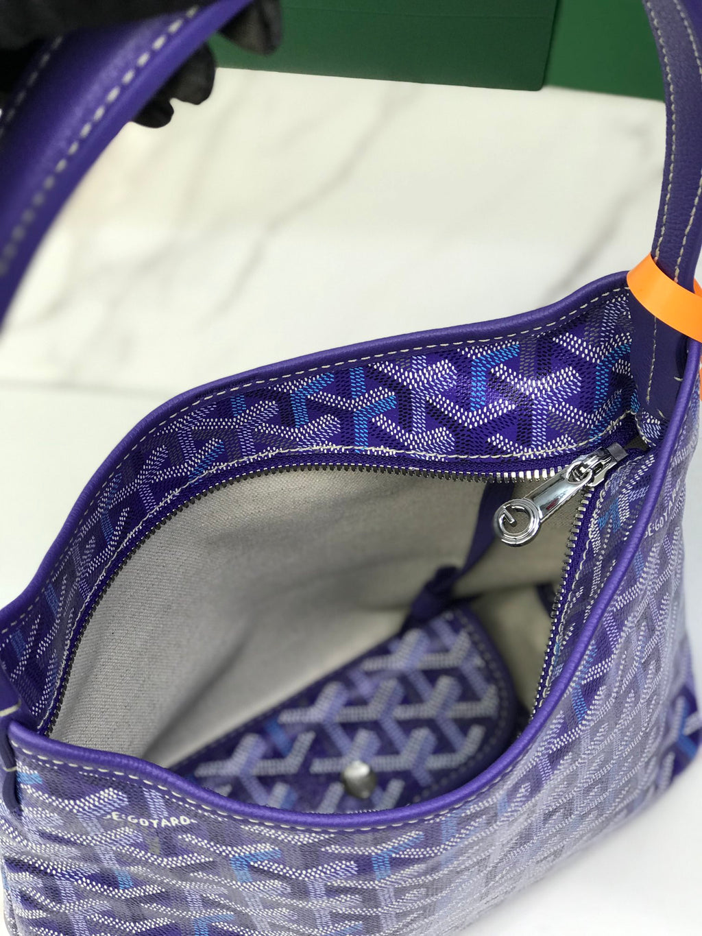 Inside view of purple Goyard patterned bag with lining and small inner pocket