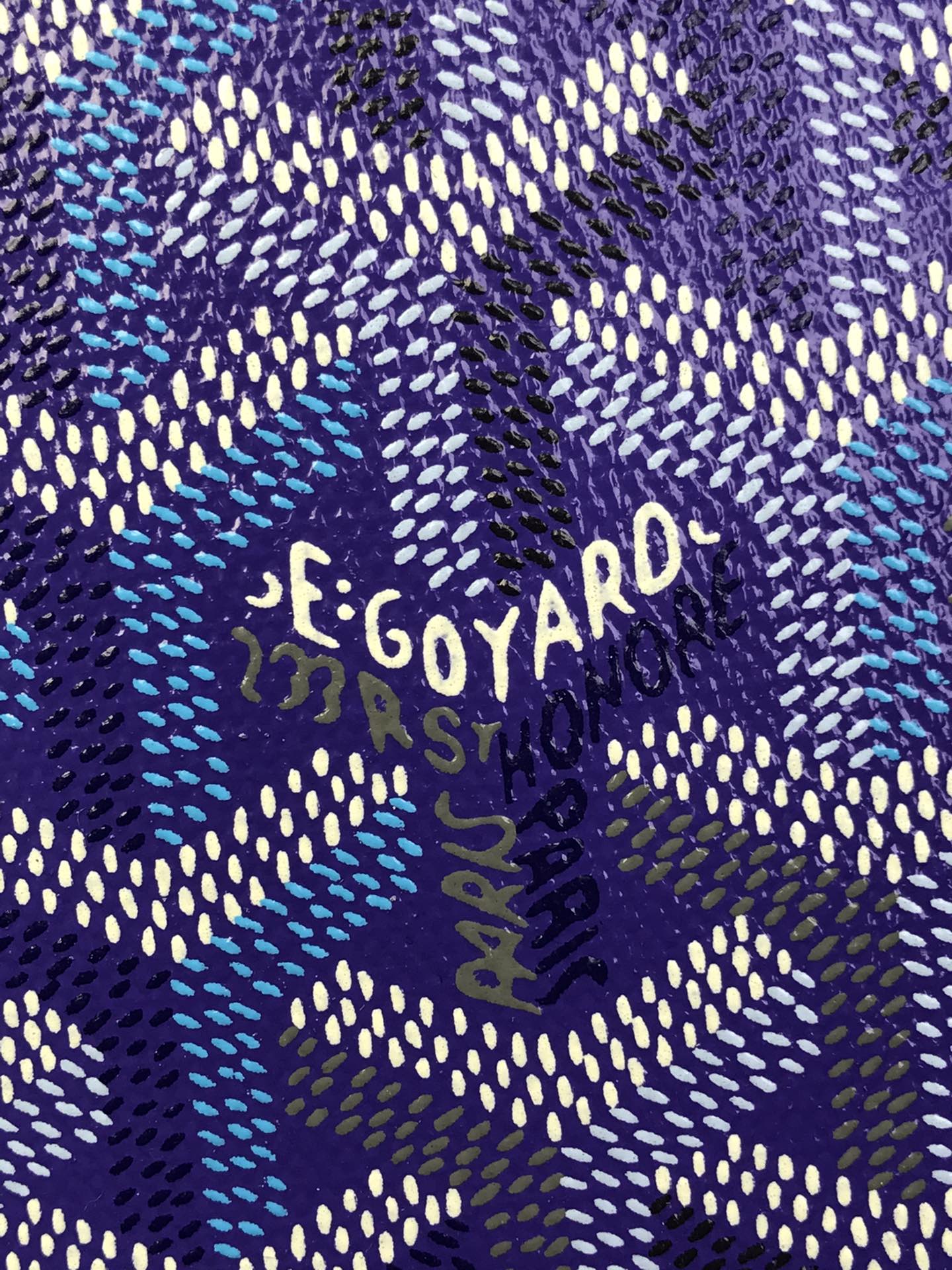 Close-up of purple Goyard patterned fabric with 'GOYARD' lettering