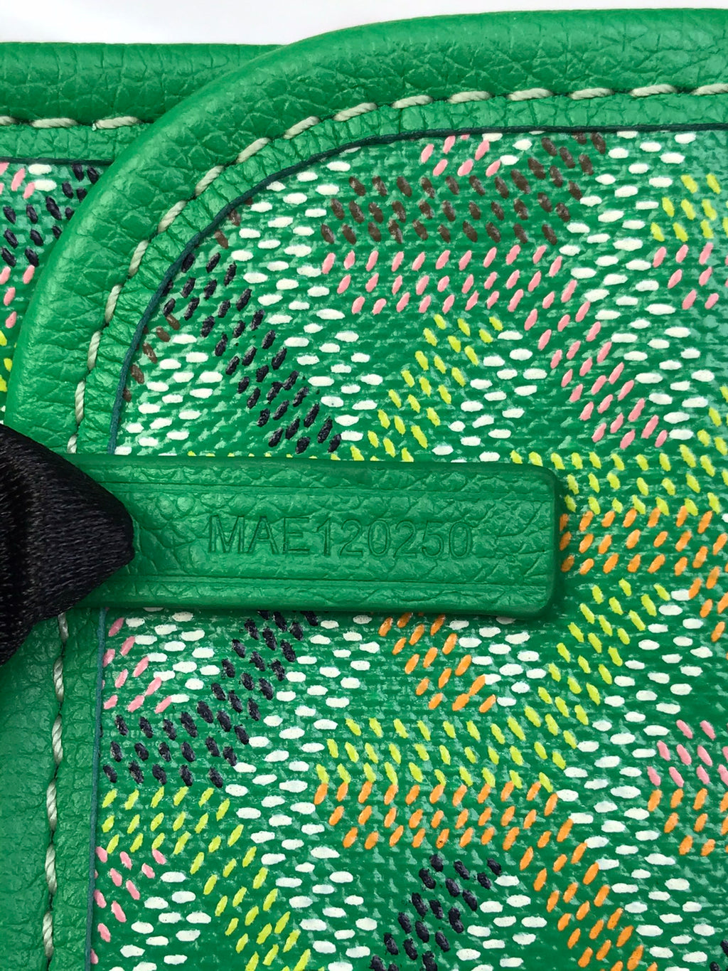 Green Goyard patterned interior lining with leather trim and label patch at edge.