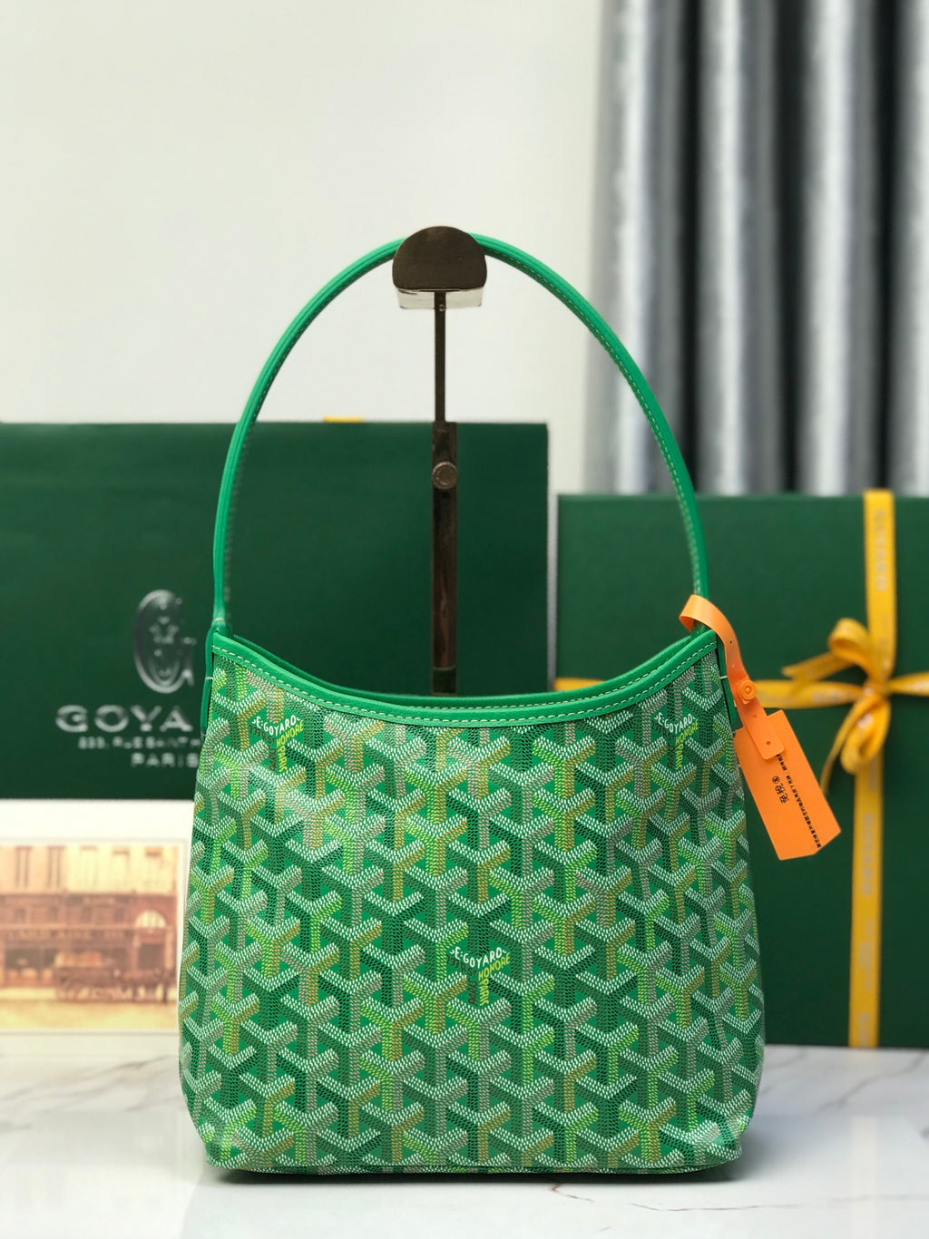 Green Goyard hobo-style tote bag with curved handle and monogram pattern.