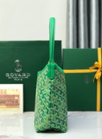 Green Goyard tote bag with monogram pattern and vertical top handle, side view.