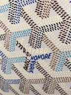 Goyardine canvas close-up with blue and gold 'PARIS HONORE' lettering
