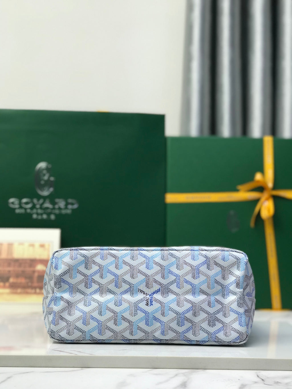 Goyard clutch in light blue with Goyardine pattern and top zipper closure