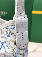 Goyard bag handle close-up with textured light leather and gold stitching
