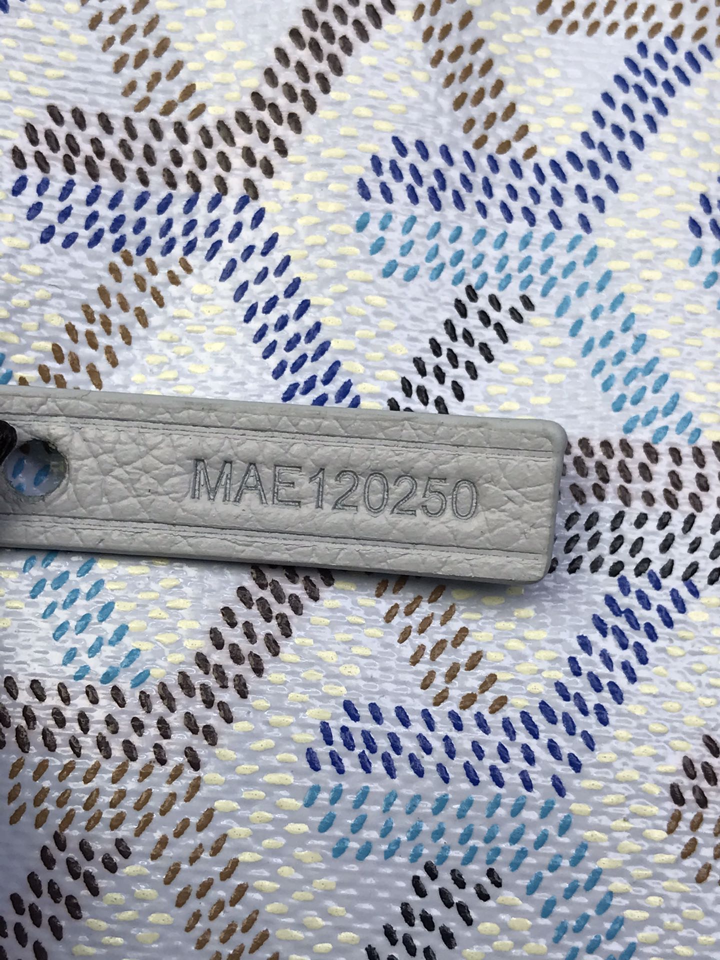 Goyard bag serial stamp 'MAE120250' on a light leather patch