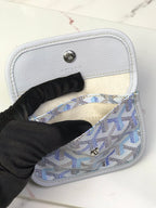 Goyard bag interior with open flap, light lining, and snap button closure
