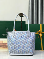 Goyard monogram tote bag with top handles, open top, and orange pull tag