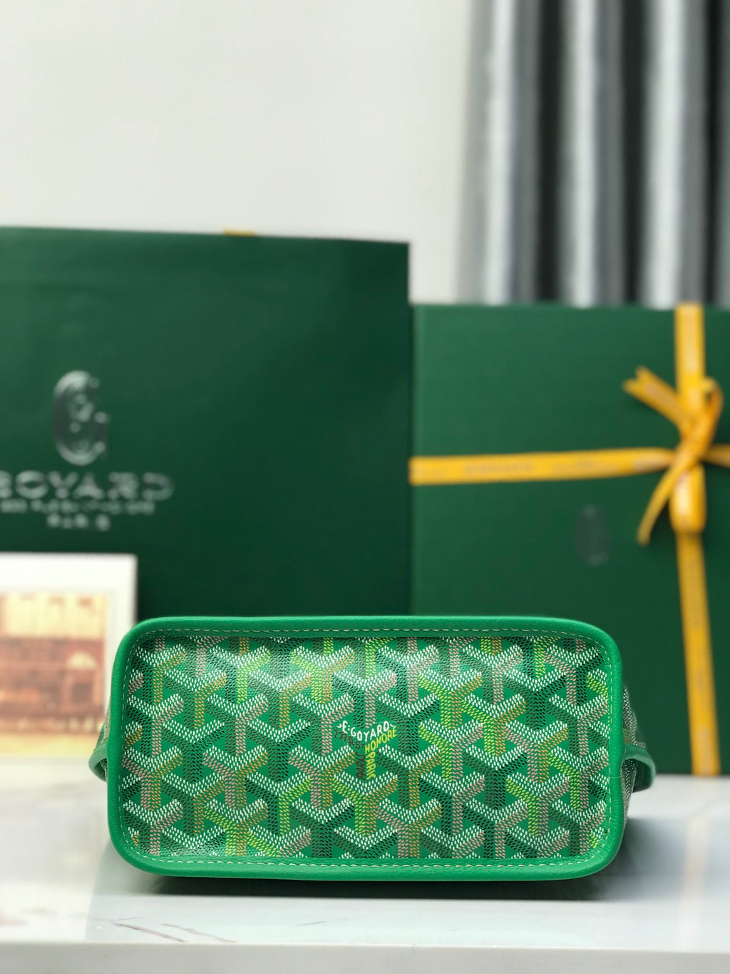 Green wristlet bag with textured Goyardine pattern and zipper closure