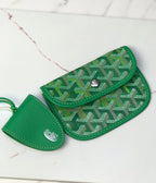 Green patterned pouch with flap closure and snap, plus small leather holder