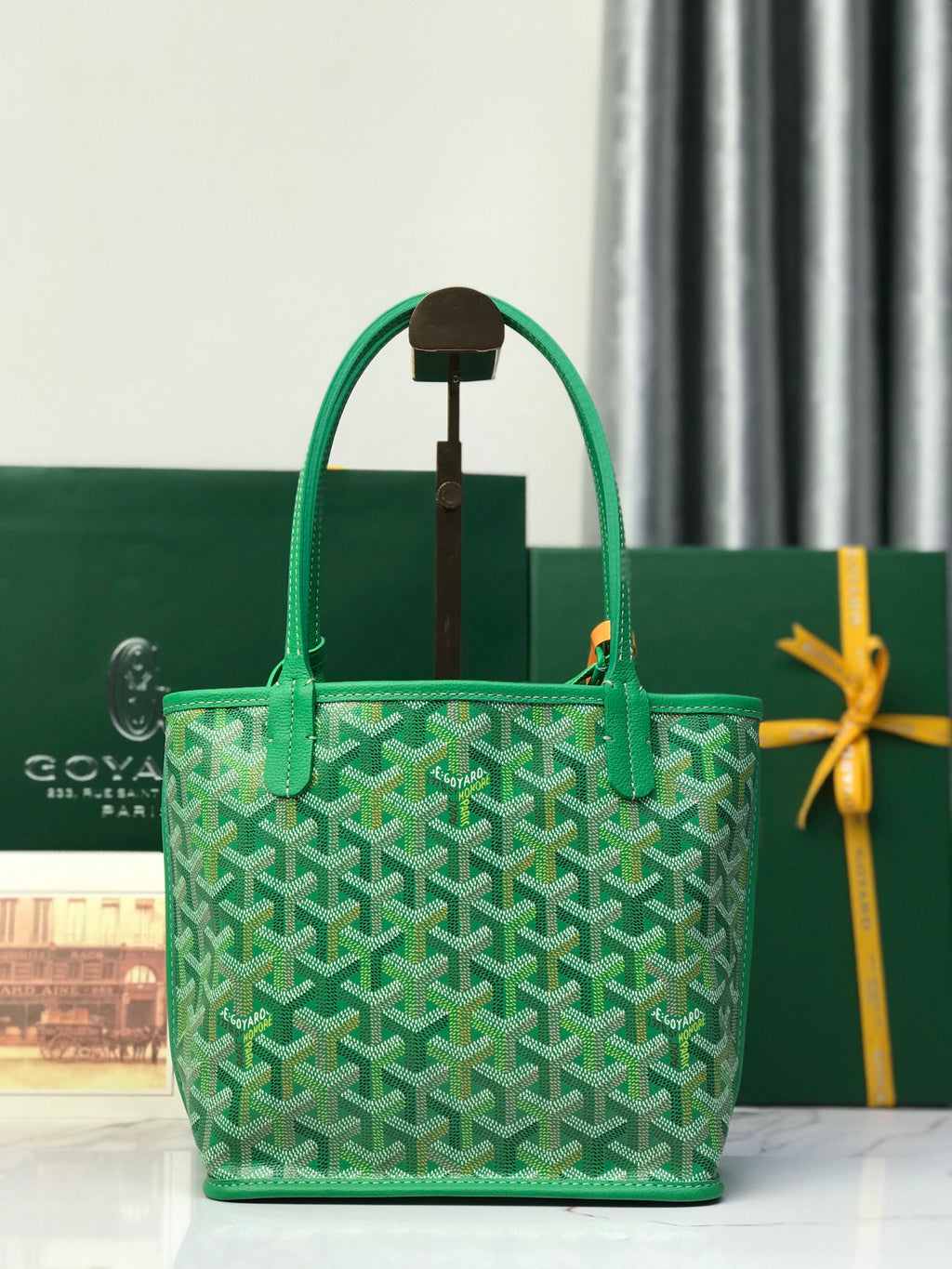 Green tote bag with textured Goyardine pattern, top handles, and center exterior strap
