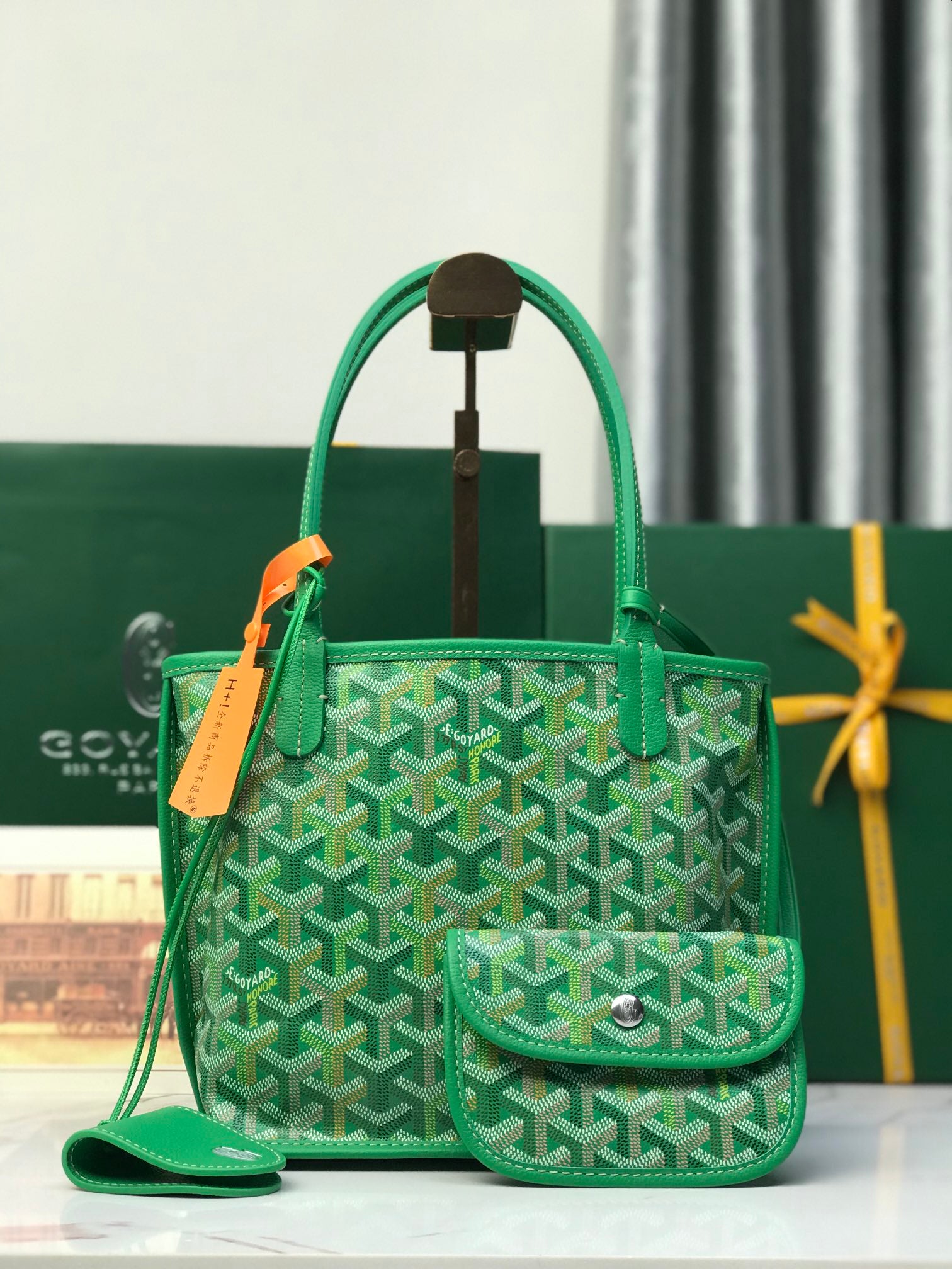 Green Goyard tote bag with textured pattern, top handles, and front pouch