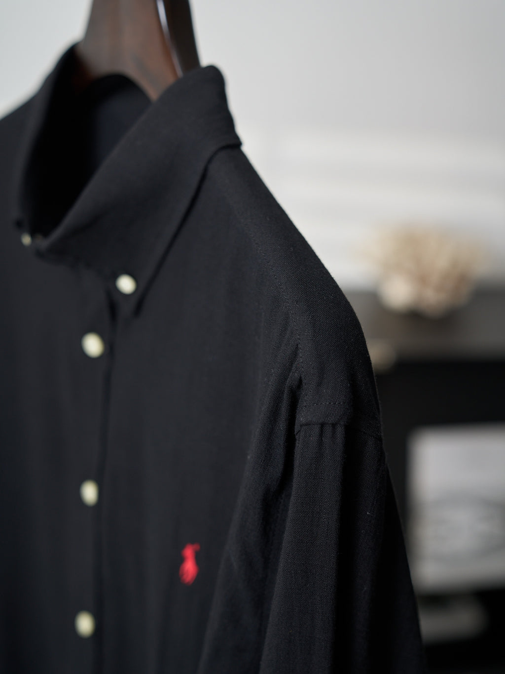 Black button-up shirt shoulder and sleeve with button detail