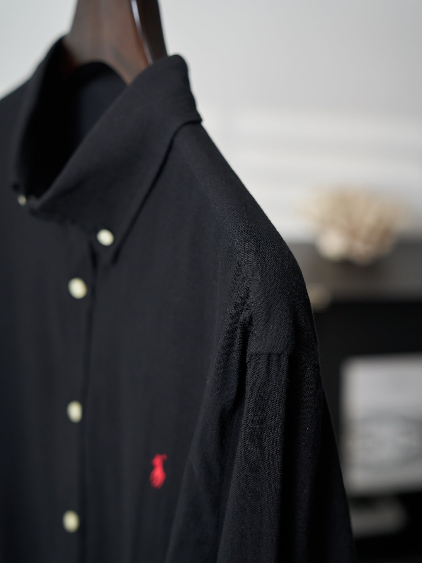 Black button-up shirt shoulder and sleeve with button detail