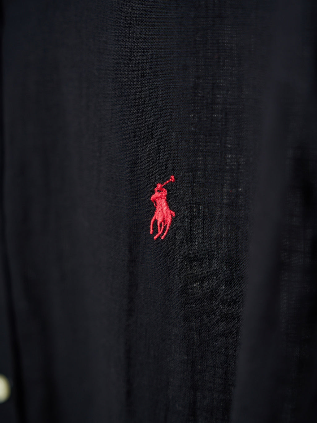 Black button-up shirt with small red polo logo on the fabric