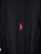 Black button-up shirt with small red polo logo on the fabric