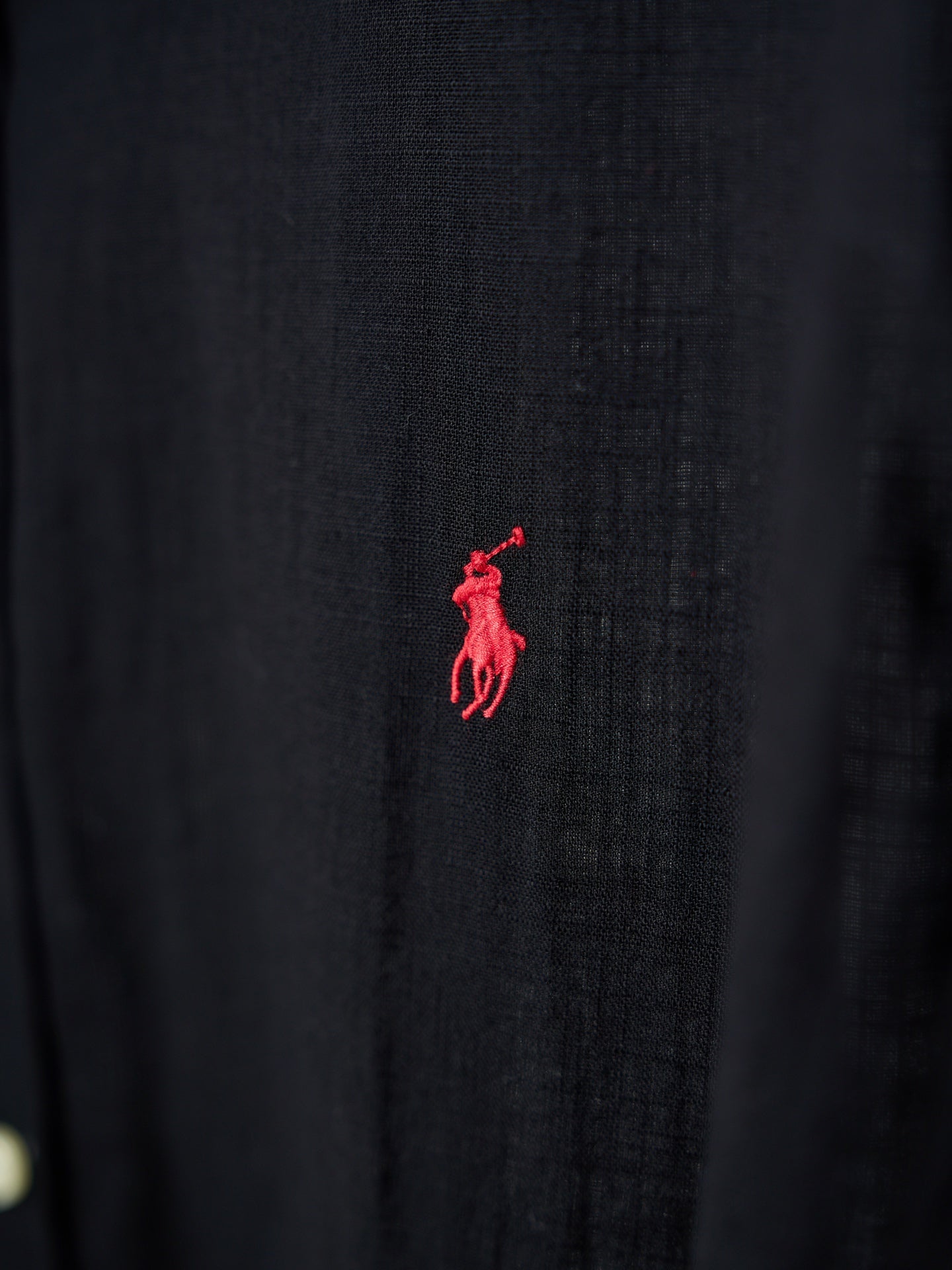Black button-up shirt with small red polo logo on the fabric