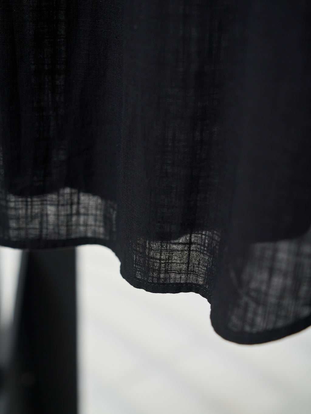 Black button-up shirt hem and lower fabric panel detail