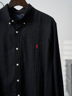 Black button-up shirt with white buttons and small red polo logo on chest