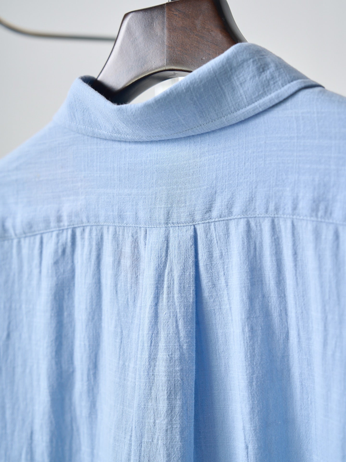 Light blue button-up shirt with spread collar and shoulder yoke seam