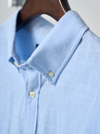 Light blue shirt cuff with yellow buttons and stitched sleeve seam