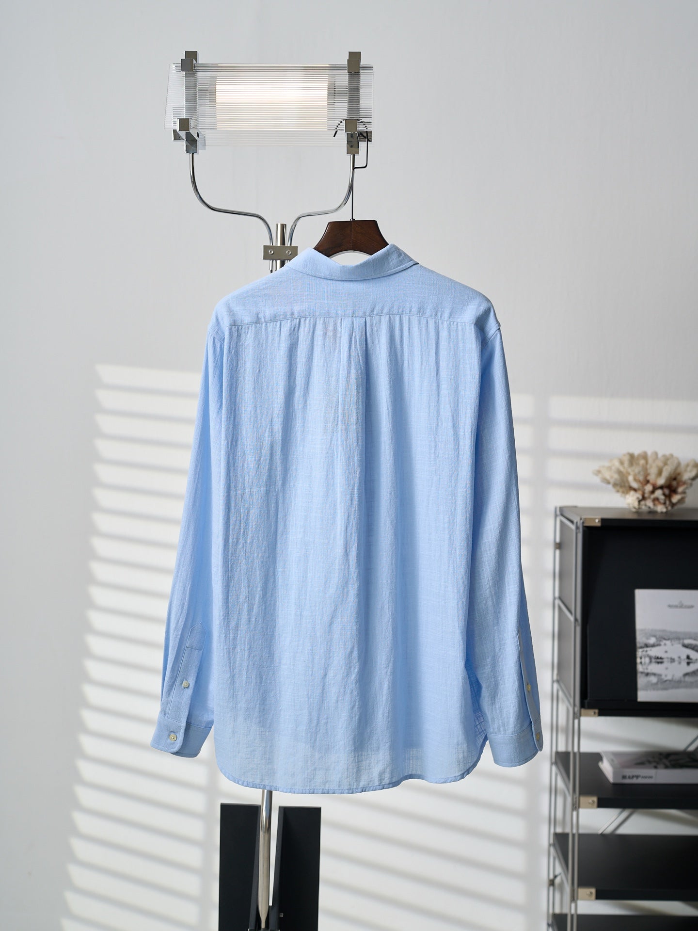 Light blue button-up shirt, back view, with full button front and long sleeves