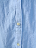 Light blue buttoned shirt placket with round yellow buttons