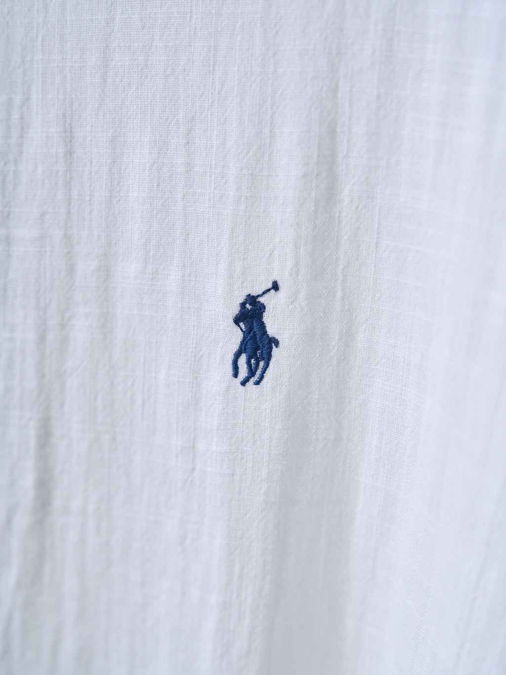 White shirt fabric with small navy polo player logo