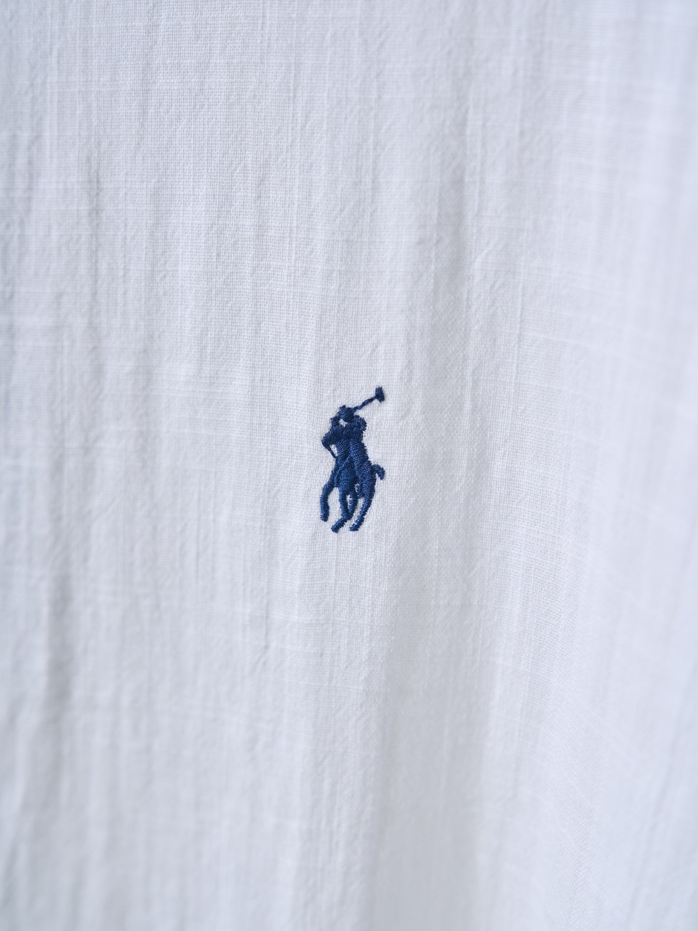 White shirt fabric with small navy polo player logo