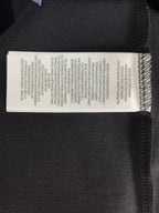 Black polo shirt interior care label with printed product instructions