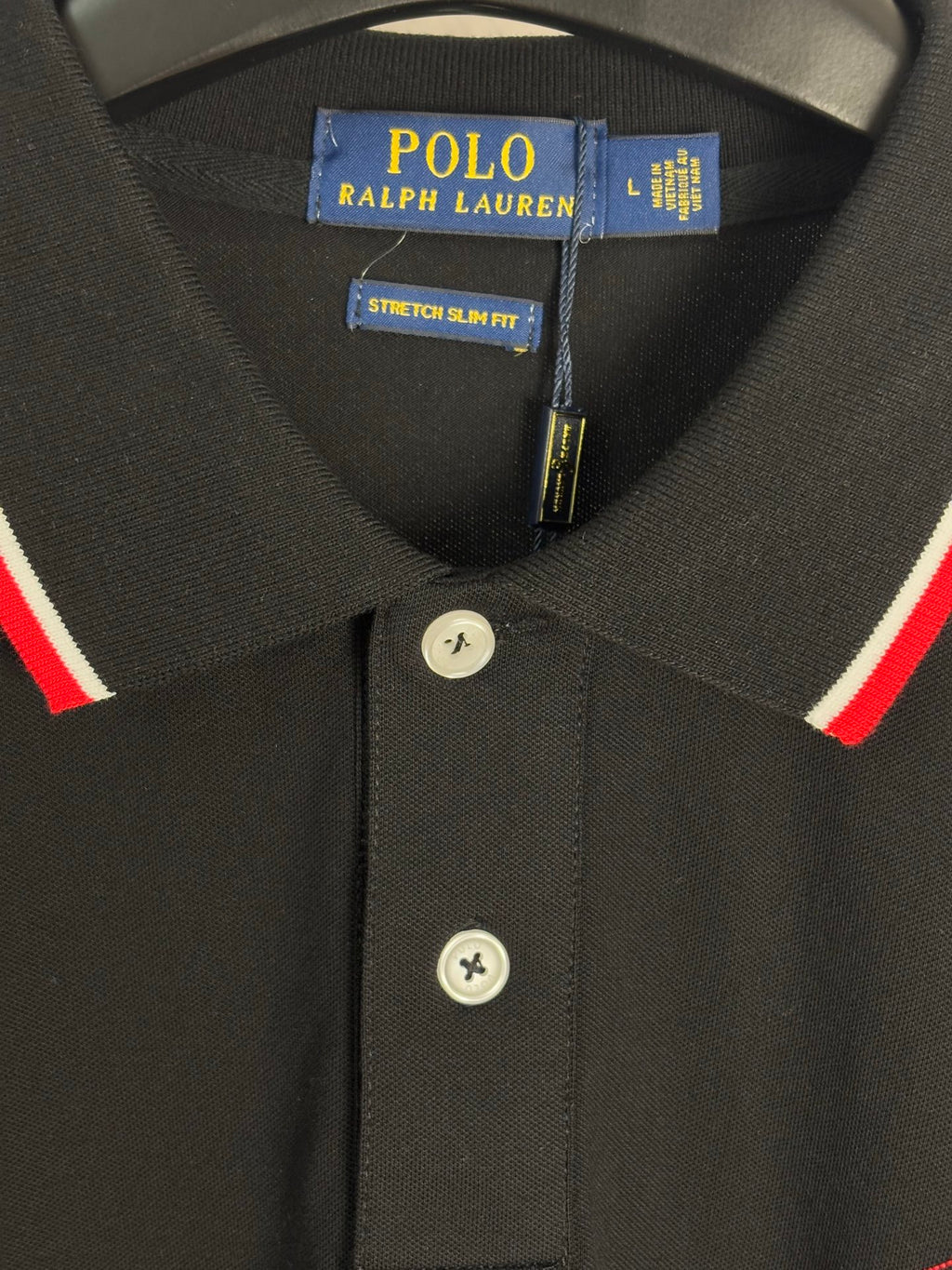 Black polo shirt collar and button placket with red and white trim