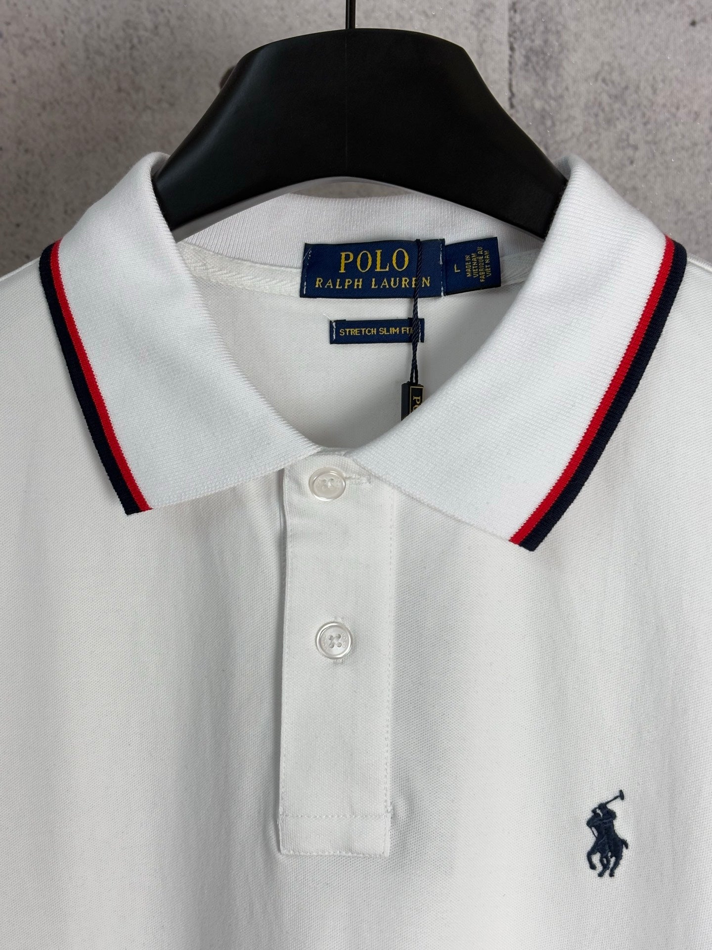 White polo shirt with red-and-navy striped collar and embroidered horse logo
