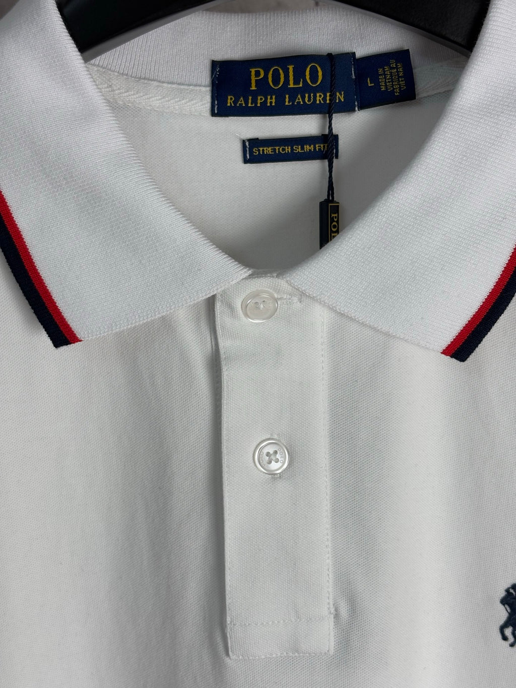 White polo shirt collar with button placket and red-and-navy striped trim