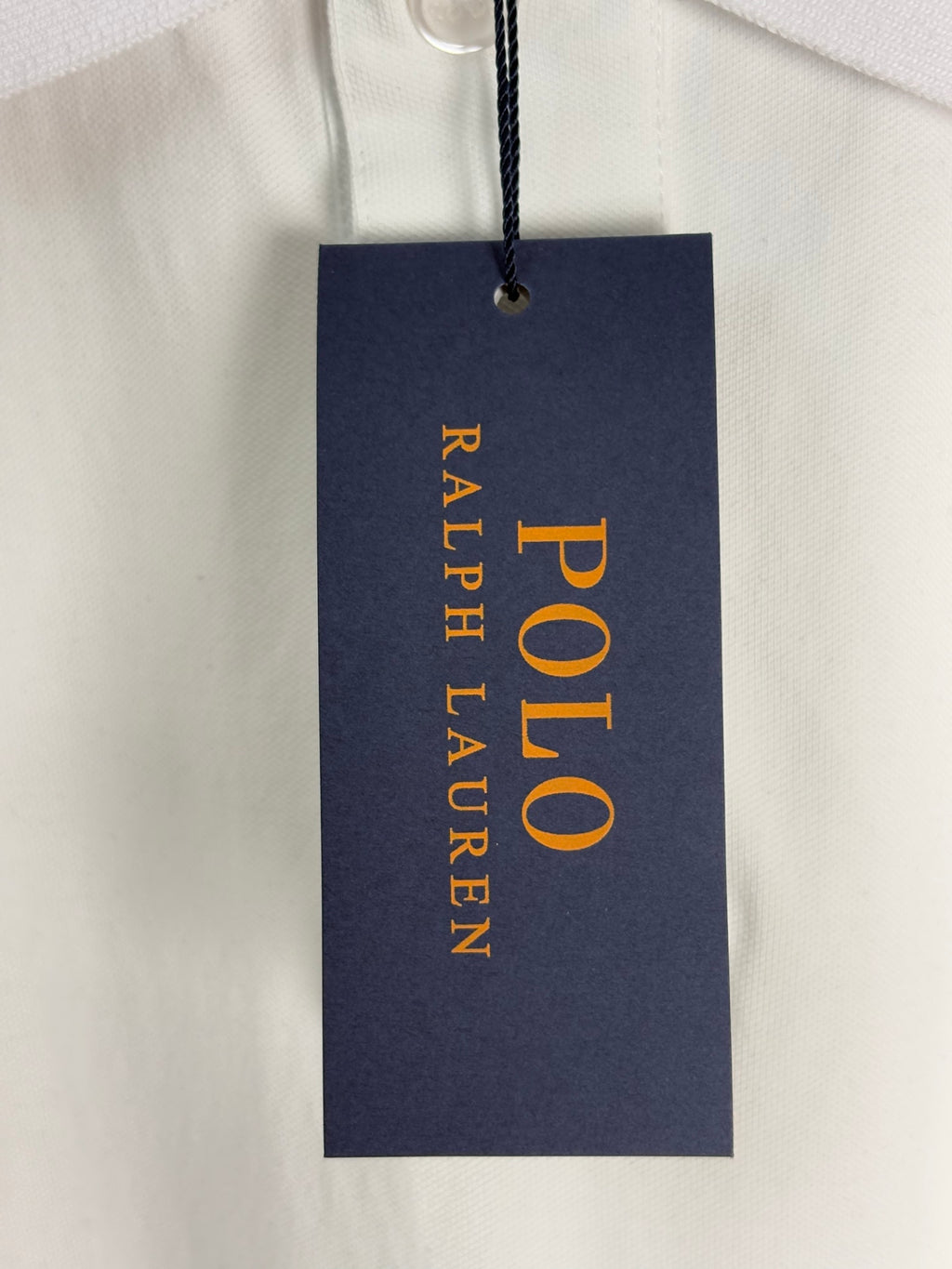 Ralph Lauren polo shirt tag hanging on white fabric