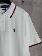 White polo shirt with embroidered horse logo and red-and-navy trim at sleeve hem