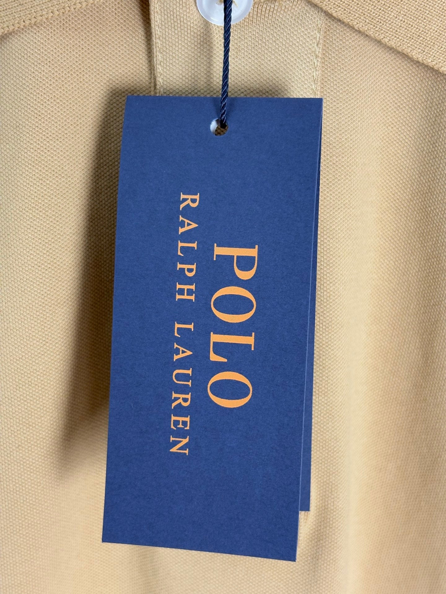 Hang tag for Polo Ralph Lauren on tan polo shirt fabric