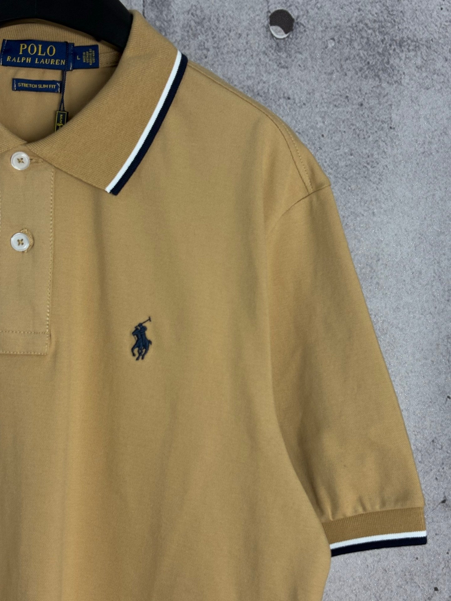 Ralph Lauren polo shirt sleeve with small embroidered logo and navy trim