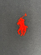 Red Polo player logo on navy polo shirt fabric
