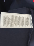 Navy polo shirt care label with washing instructions