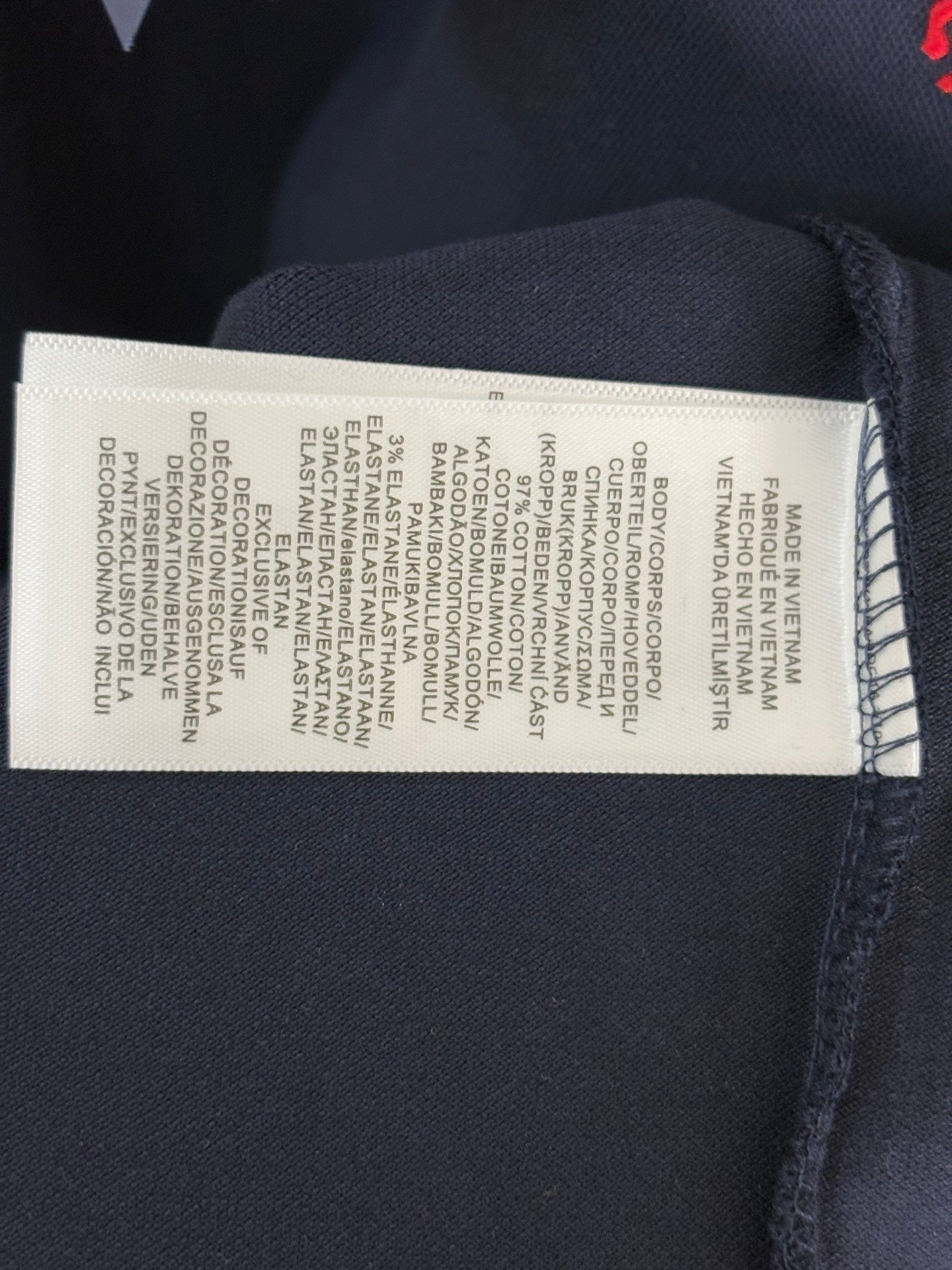 Navy polo shirt care label with washing instructions