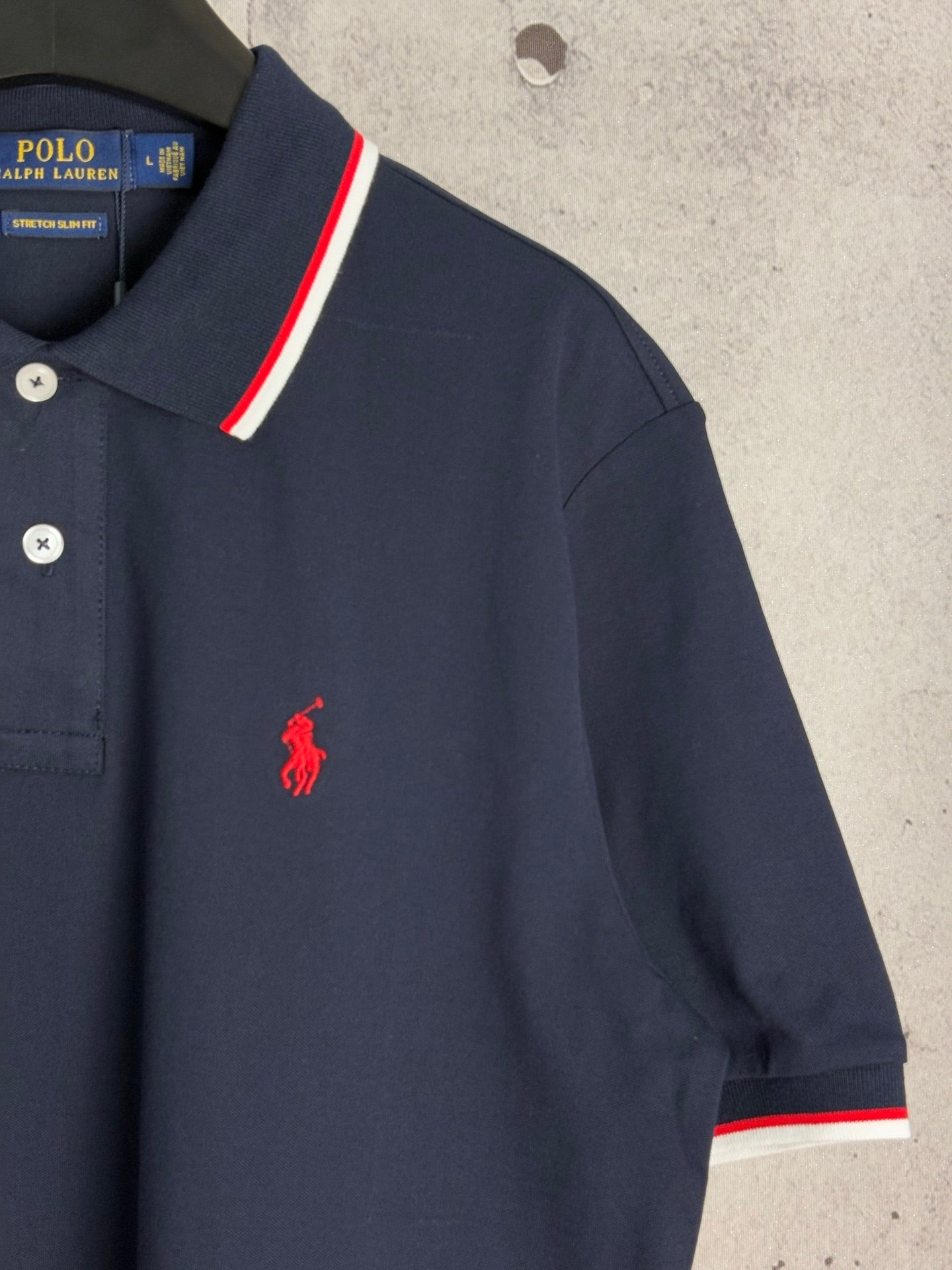 Navy polo shirt with red Polo player logo and striped sleeve cuff